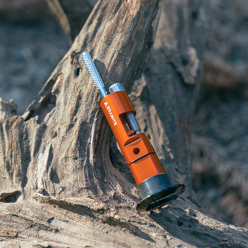 Granite Stash chain tool resting on a rugged tree trunk, highlighting its durable design and outdoor functionality.