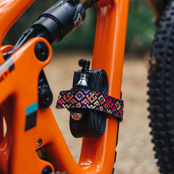 Granite Rockband with square tile pattern secures a CO2 canister with granite punk CO2 inflator and tube to an orange bike frame.