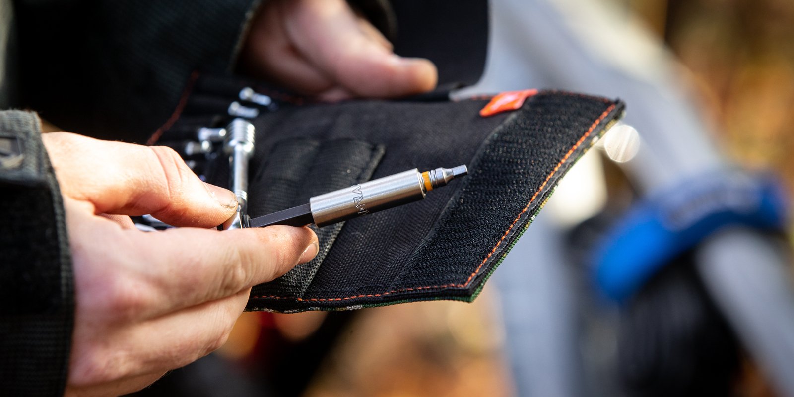 Close-up of hands holding Granite ROCKnROLL Mini Ratchet Tool Kit, showcasing a bit in use for quick bike repair and adjustments.