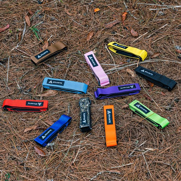 Granite Rockband frame straps in various colors displayed on a forest floor, offering vibrant options for outdoor biking gear.
