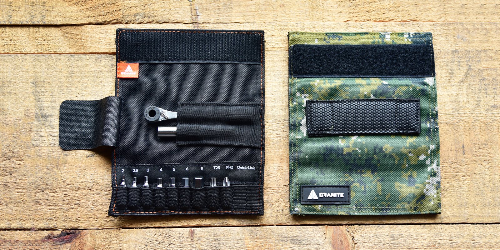A compact black tool kit with multiple screwdriver bits and a ratchet sits open next to its closed camouflage case, both placed on a granite wooden surface.