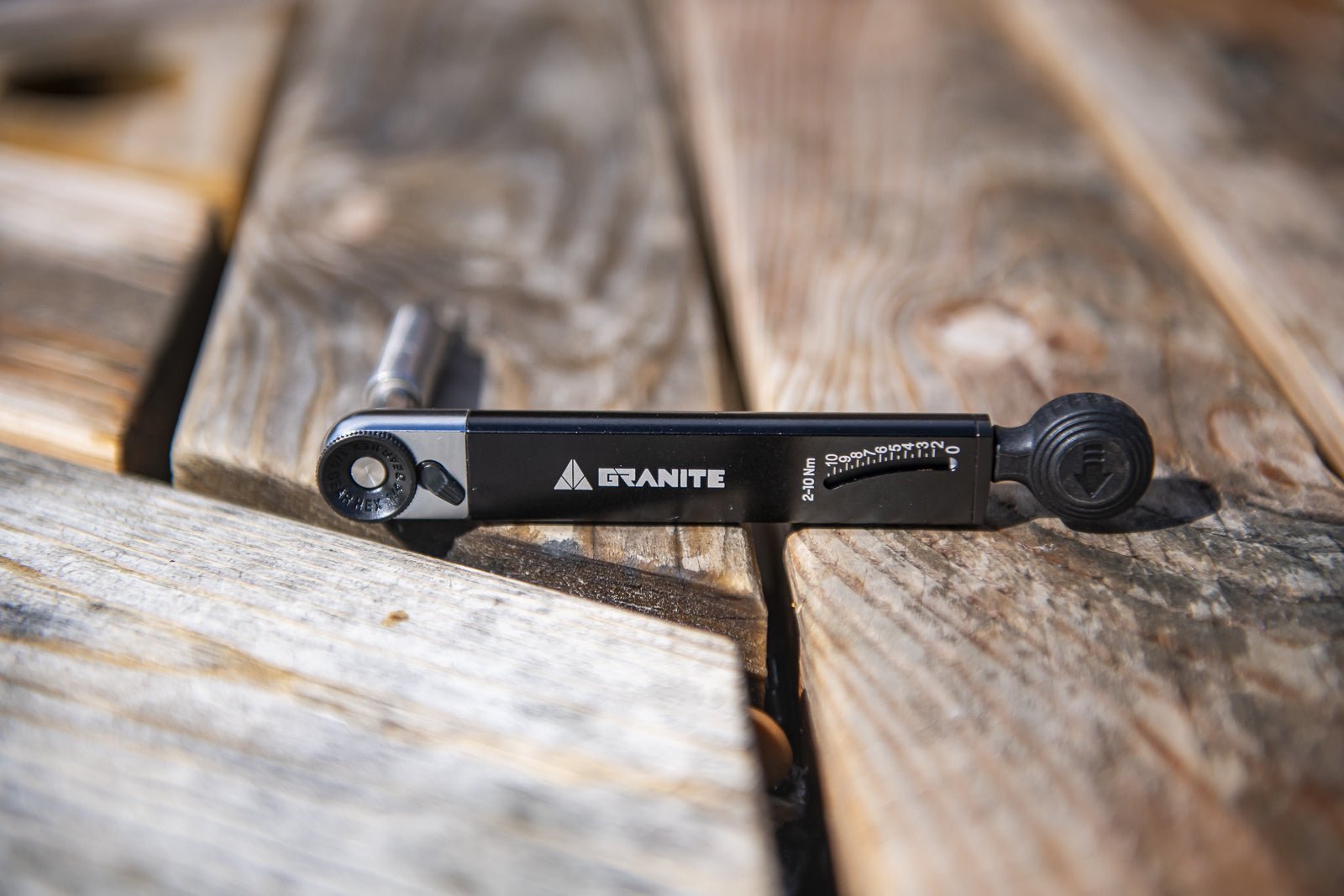 Granite RocknRoll TQ torque wrench resting on rustic wooden planks, highlighting its precision and sturdy construction.