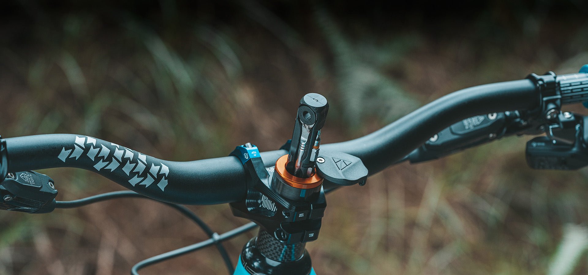 Granite Stash RT Ratchet Tool Kit in orange mounted on a bike's handlebar stem, displaying tool bits in a compact setup. Granite Design