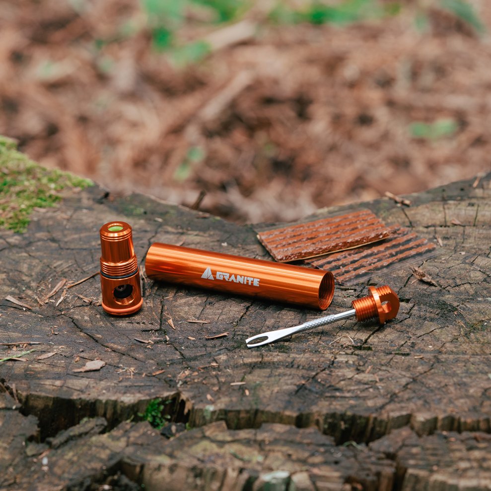 Granite Suture Aero orange tool set with a cylindrical container on wood background
