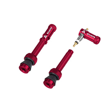 Two red Granite bicycle tubeless valve stems with black rubber bases and a matching red valve core removal tool, all branded with the name Granite, displayed on a white background.