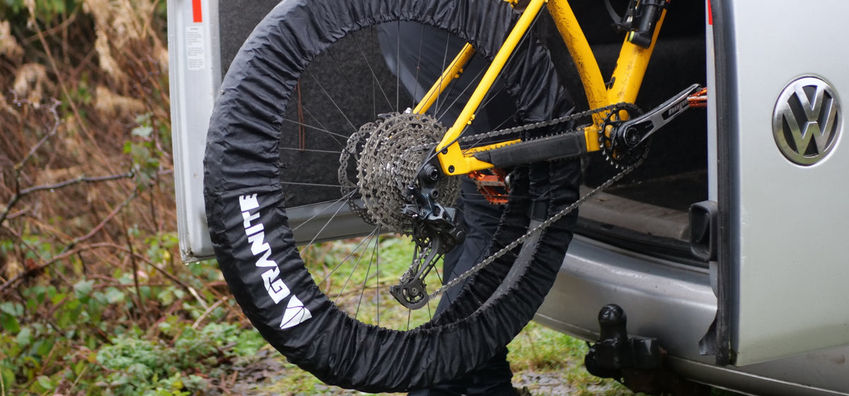 Rider loading a yellow mountain bike with Granite Crust covers on both wheels into a van