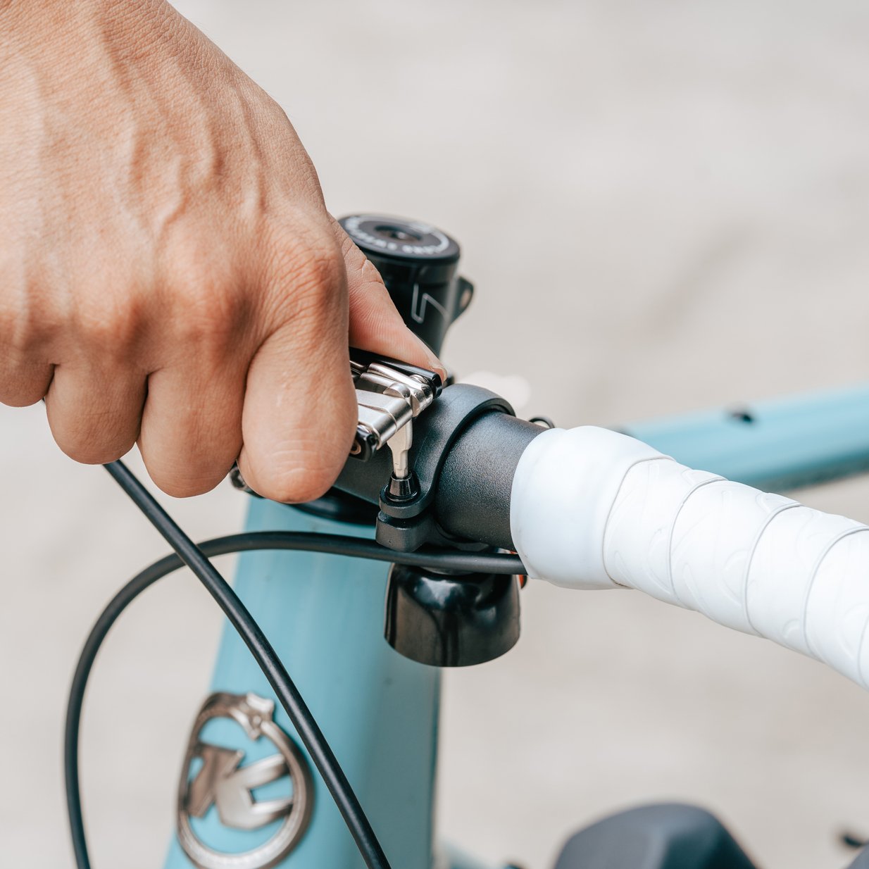 Person using Granite Diverse 10 multi tool gripping bicycle handlebars with a blurred background