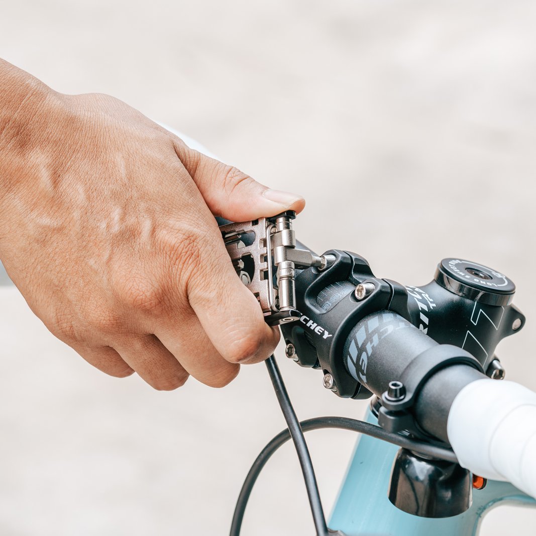 Granite Diverse 20 multi tool gripping a bicycle handlebar with a blurred background