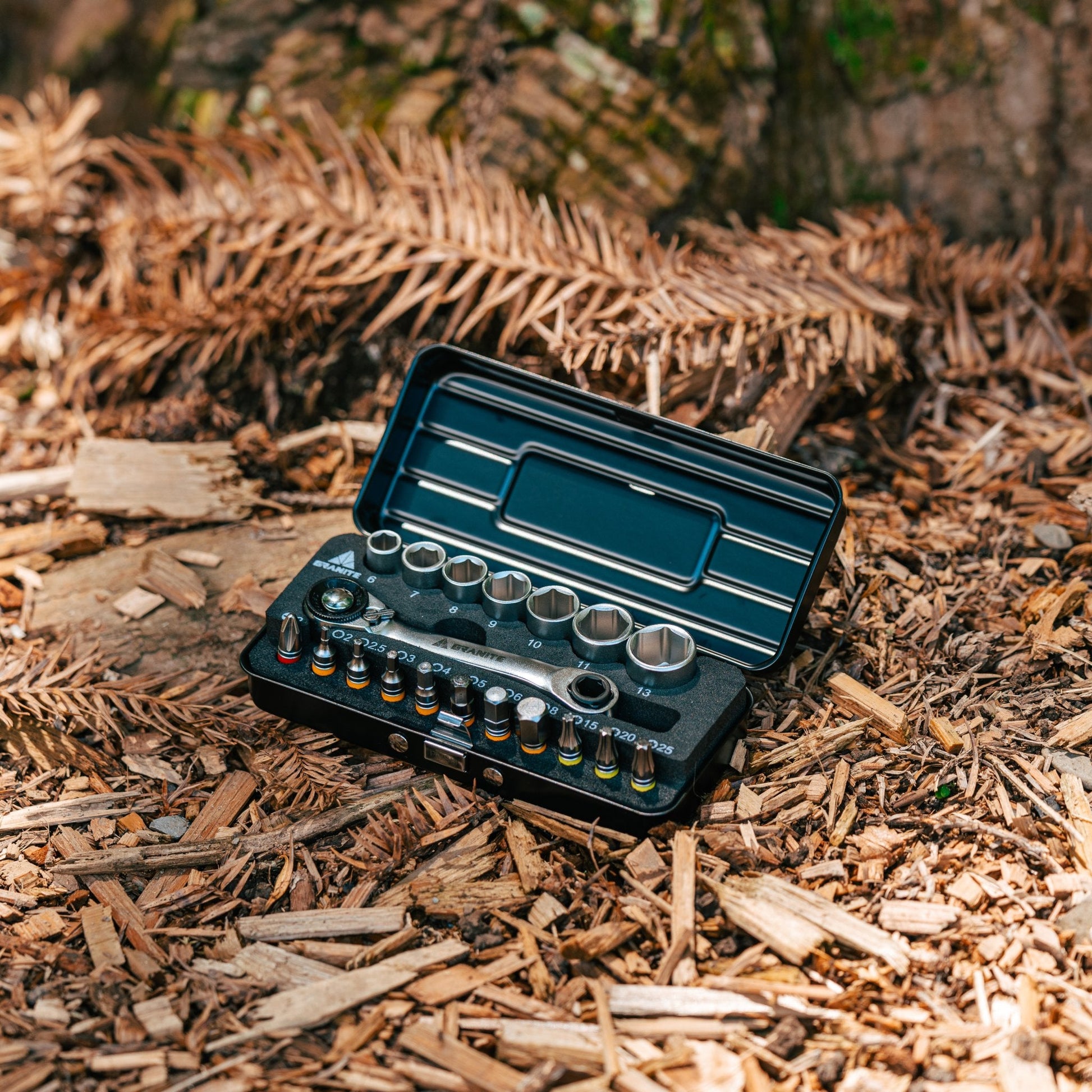 Granite Duet Hex Bit & Socket Ratchet Tool Kit with sockets and bits displayed in an open case on forest floor.