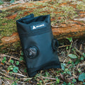 Granite Quiver Tool Roll with roll-top closure and ratchet dial, resting against a mossy log outdoors.