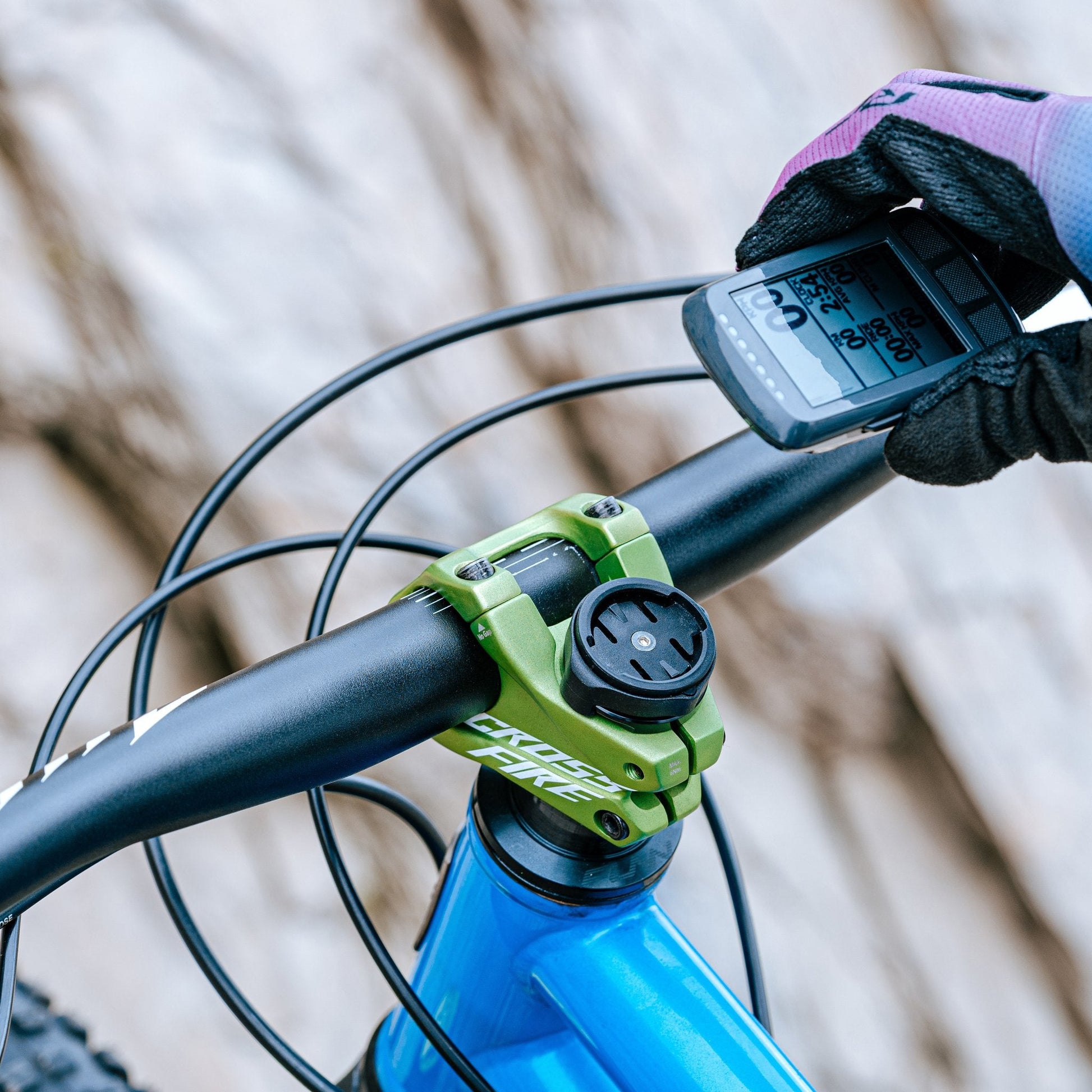 Cyclist hand placing a Wahoo device onto a Granite Scope Mount for Stash RT, compatible with multiple devices.