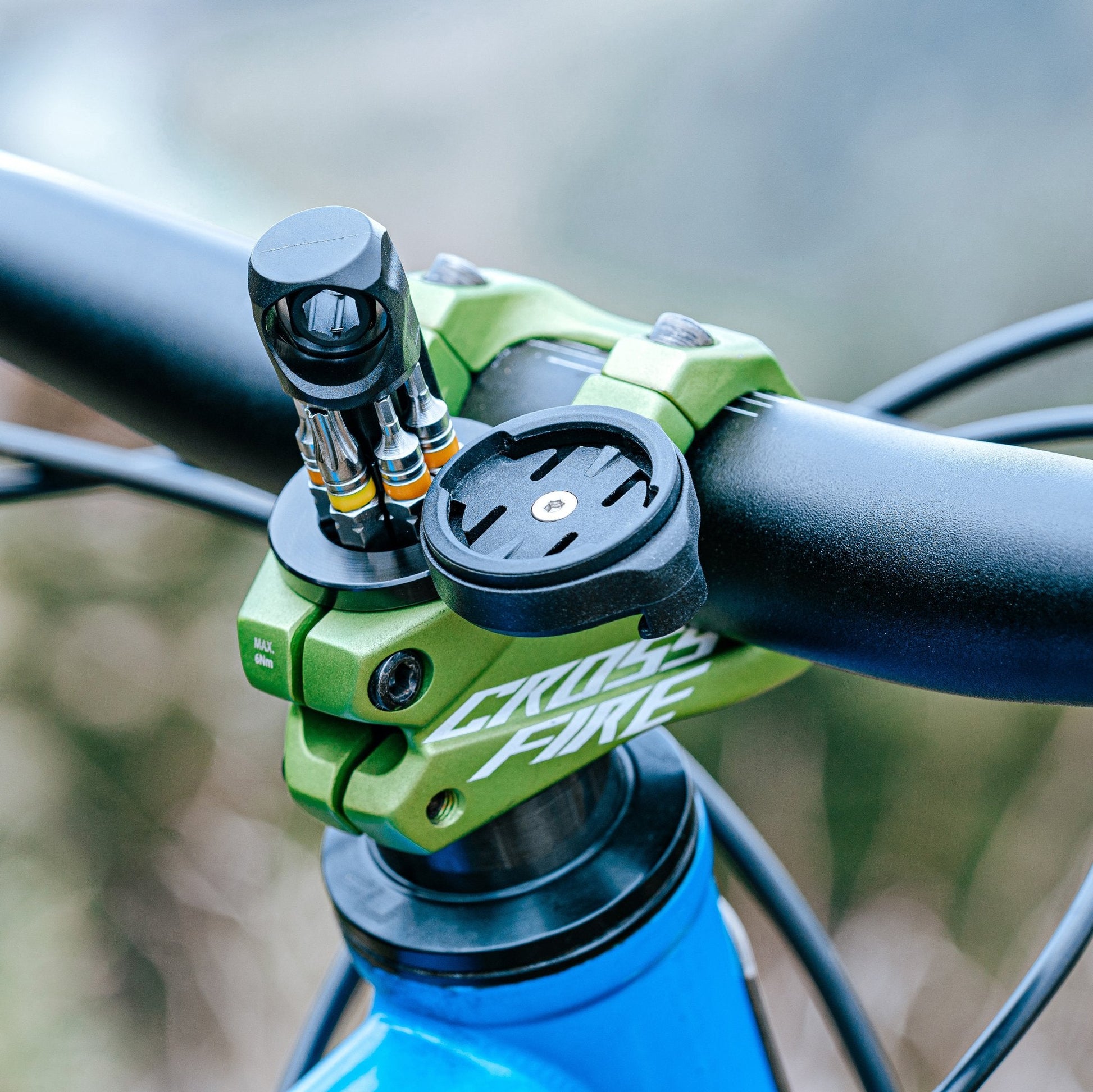 Close-up of a green Crossfire bike stem with a Stash RT multitool with Scope cycling computer mount attached.