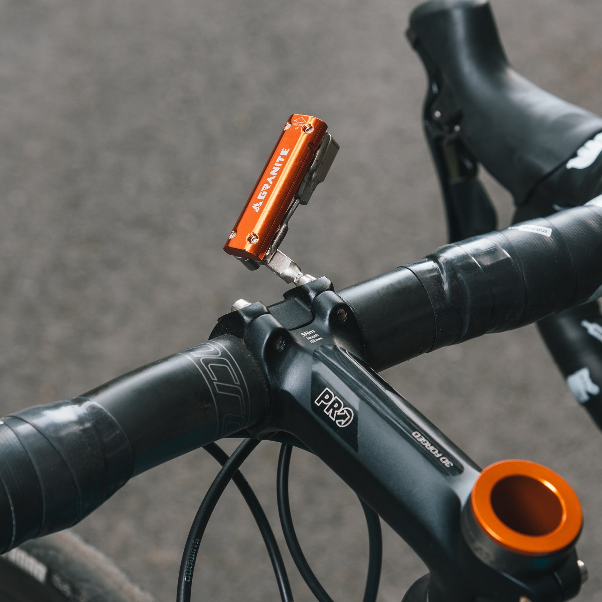 Granite RCX multitool attached to a bike handlebar stem, with the tool extended upward for easy access.