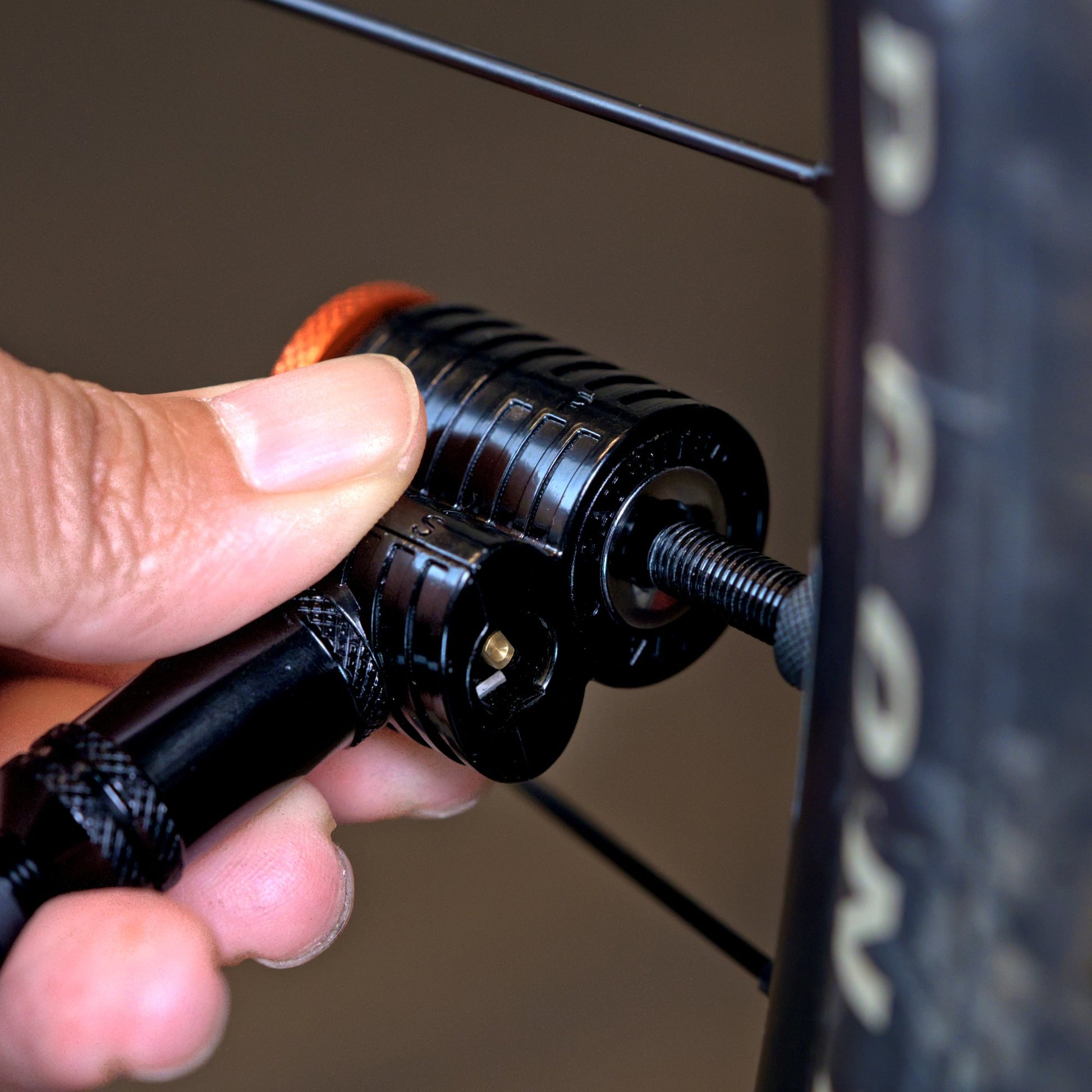 Hand pushing a Granite Quickie pump head straight onto a gravel bike tire valve