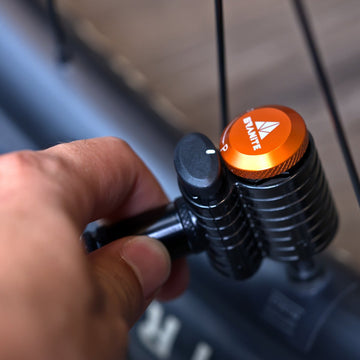 Thumb pressing the black release button on a Granite Quickie pump head locked onto a mountain bike valve