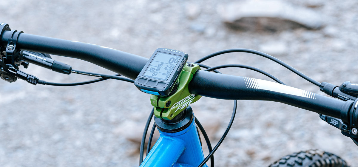 Wahoo bike computer on a Granite Scope mount above a green stem on a blue mountain bike