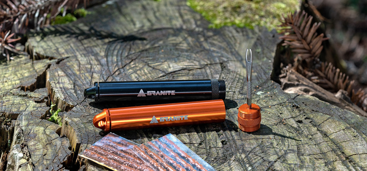 Black and orange Granite Suture tire plug kits with brown tire plug strips on a mossy tree stump
